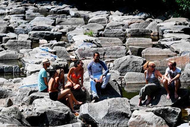 Franzsische Studenten sitzen auf Steinen in der Dreisam.  | Foto: dpa