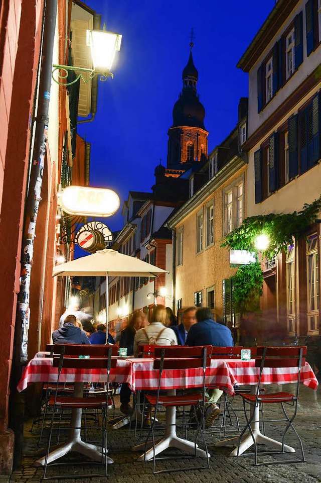 Gste einer Heidelberg Gaststtte sitz...ch der Dunkelheit unter freiem Himmel.  | Foto: dpa