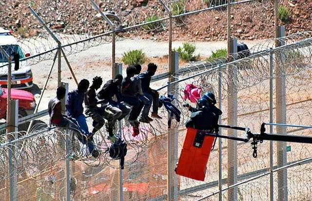 Flchtlinge sitzen auf dem Grenzzaun, ...es Foto stammt aus dem September 2016.  | Foto: dpa