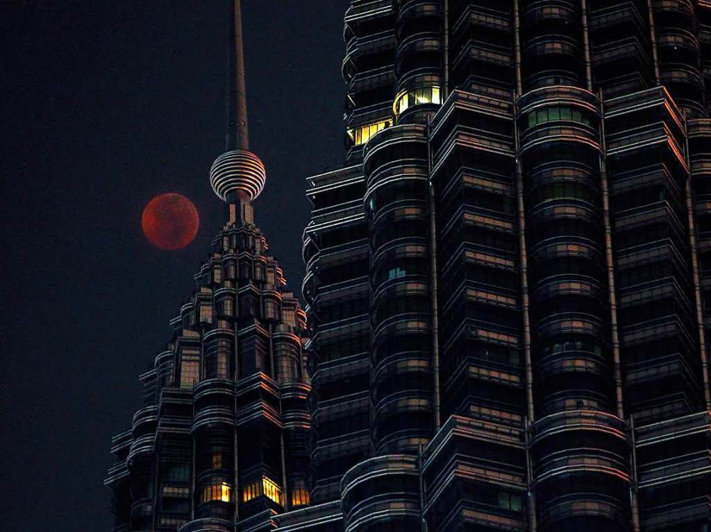 Der rötlich gefärbte Vollmond erhebt sich über dem Petronas Twin Tower in Kuala Lumpur (Malaysia) Der rötlich gefärbte Vollmond erhebt sich über dem Petronas Twin Tower in Kuala Lumpur (Malaysia)
