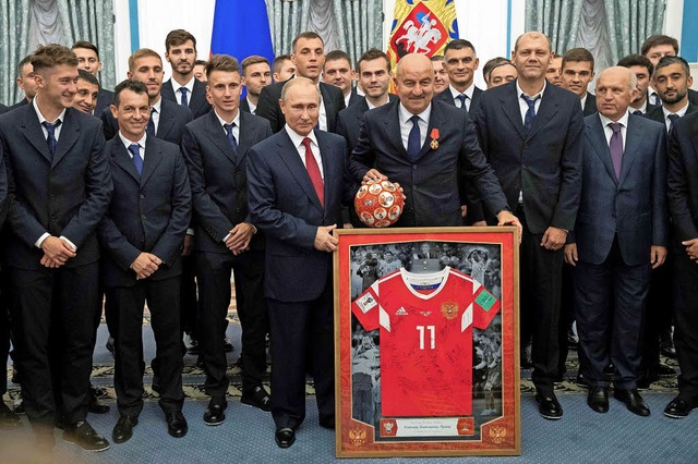 Putin, wie er sich gerne sieht: Der Pr...gt das russische Fuballteam im Kreml.  | Foto:  dpa