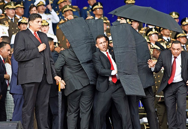 Sicherheitsbeamte schtzen Prsident Maduro bei dem Vorfall.   | Foto: dpa
