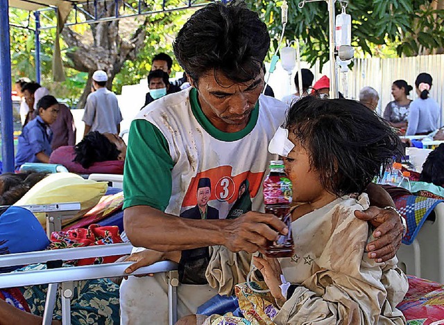 Notdrftig werden die Verletzten auf Lombok von Helfern versorgt.   | Foto: AFP