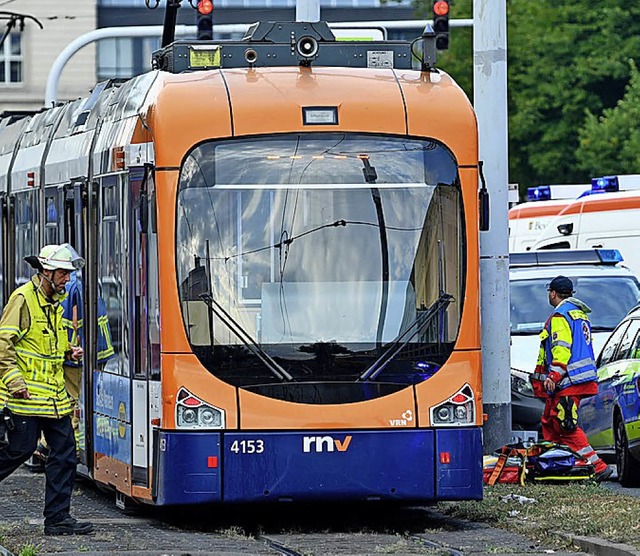 Rettungskrfte  stehen an einer der be...unglckten Straenbahnen in Mannheim.   | Foto: dpa