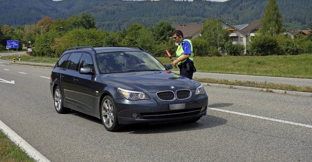 Lukas Koller kontrolliert einen Autofa...zialist durchsucht ein Auto (rechts).   | Foto: Felix Held