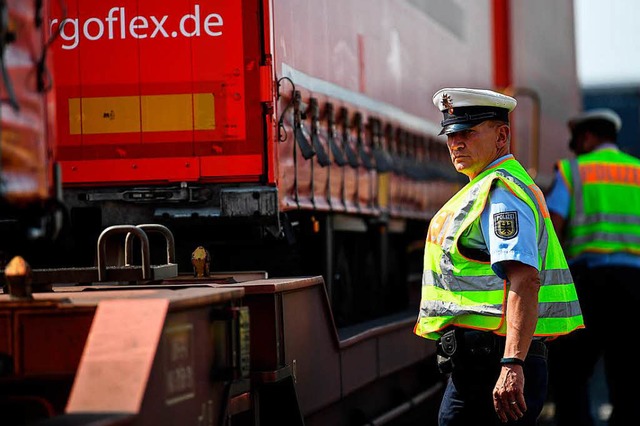 Zwei Bundespolizisten kontrollieren au...enze einen Gterzug mit Lkw-Auflieger.  | Foto: dpa