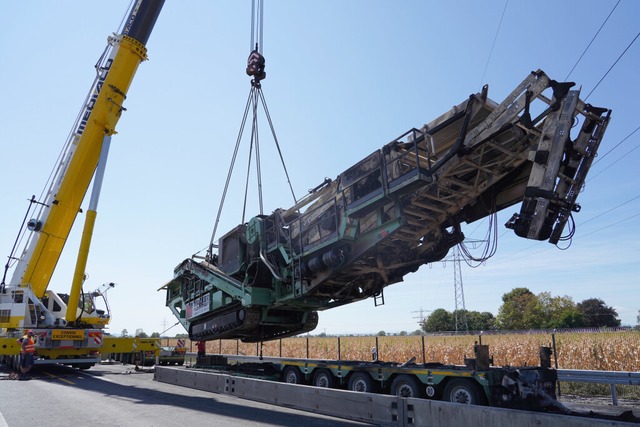 Ein eigens herbeigeschaffter Kran hat die abgebrannte Schwerlast am Haken.  | Foto: dpa