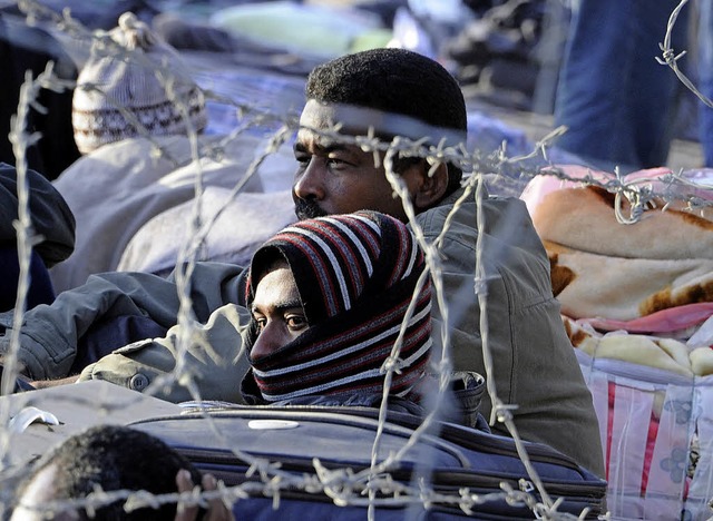 Afrikanische Flchtlinge in einem libyschen Lager hinter Stacheldraht.   | Foto:  AFP