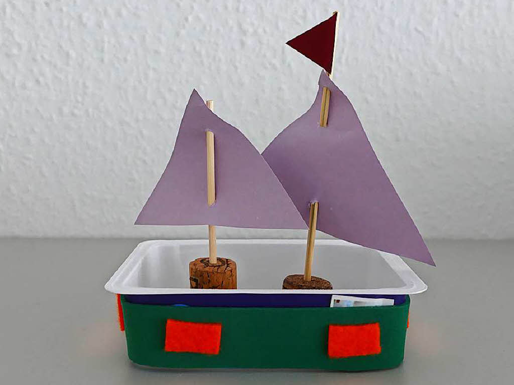 Schneide ein (oder zwei) Fhnchen aus Tonpapier aus und klebe es an die Mastspitze(n). Fertig ist dein Segelboot. Viel Spa damit!