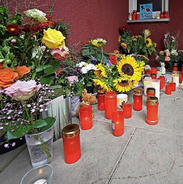 Blumen und Kerzen stehen an der Arztpraxis  | Foto: dpa