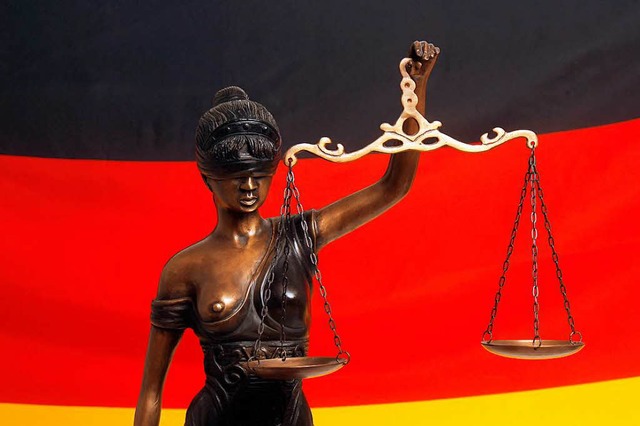 Justitia, die rmische Gttin der Gere...htswesens, vor einer Deutschlandfahne   | Foto: dpa