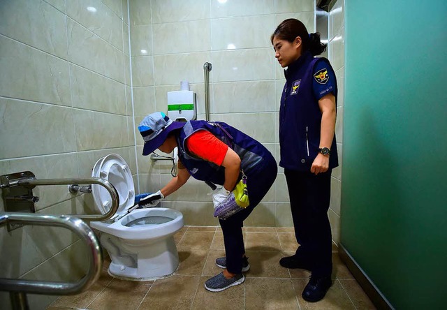 Polizisten checken eine Toilette in Seoul.  | Foto: JUNG YEON-JE