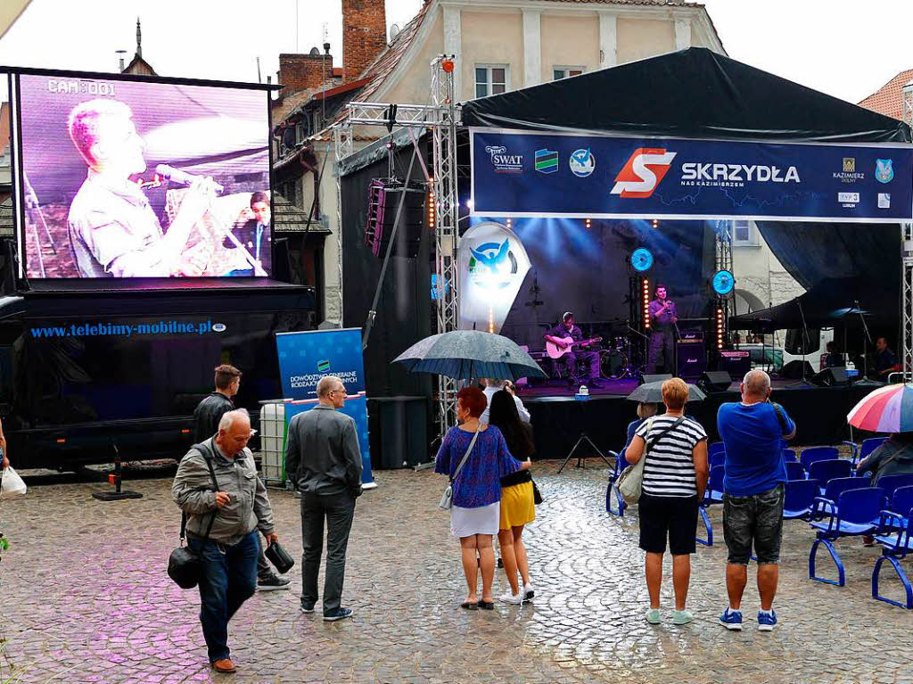 Die Delegation wurde von einem Riesen-Regenschauer berrascht und in den Kolonnaden auf dem Marktplatz festgehalten.