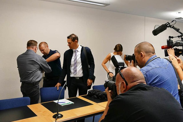 Zum Prozessauftakt wird der Angeklagte in Handschellen in den Saal gefhrt.  | Foto: Mark Alexander