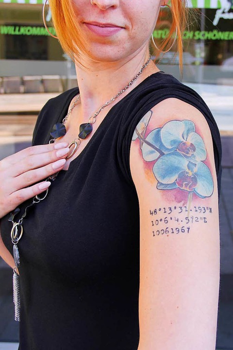Auf ihrem Arm hat sie blaue Orchideen und Koordinaten tättowiert.  | Foto: Carla Bihl
