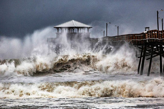 Wellen brechen an einem Pier in Atlant...222;Florence&#8220; der Region nhert.  | Foto: dpa