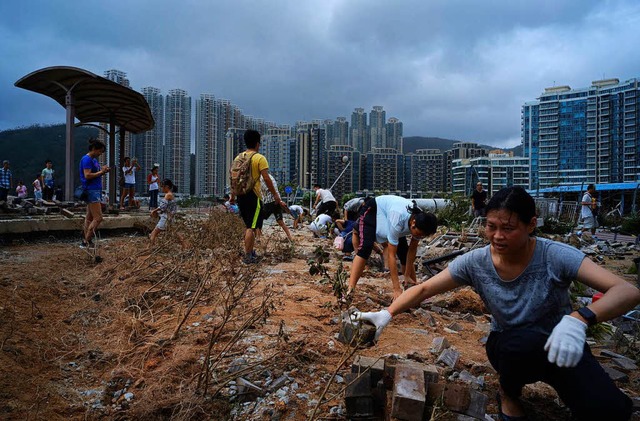 Menschen rumen mit bloen Hnden Stei...fenviertel von Hongkong gelandet sind.  | Foto: dpa