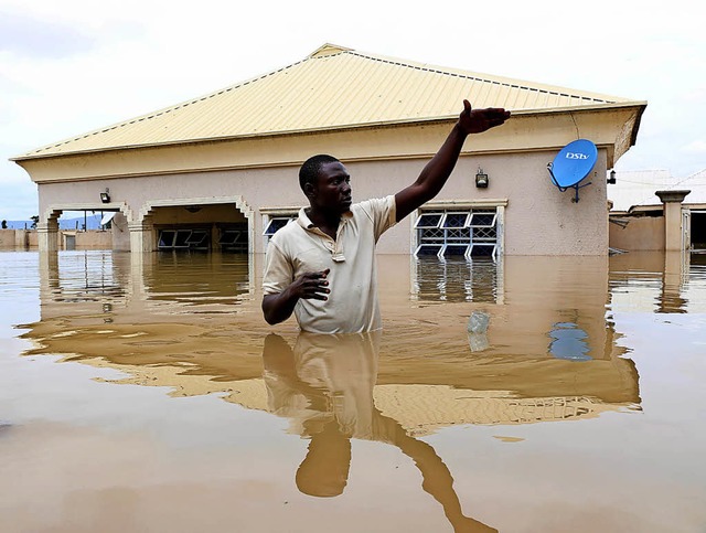 Alles unter Wasser: ein Mann vor seinem Haus in der Stadt Lokoja   | Foto: AFP