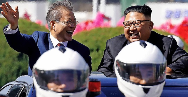 Moon (links) und Kim jubeln bei der Fahrt durch in Pjngjang.   | Foto: afp