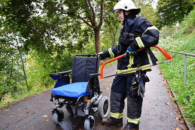 Ein Feuerwehrmann mit dem geborgenen Rollstuhl  | Foto: Kamera 24