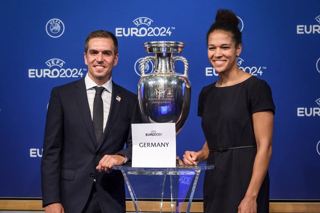 Philipp Lahm und Celia Sasic posieren mit dem EM-Pokal.  | Foto: AFP