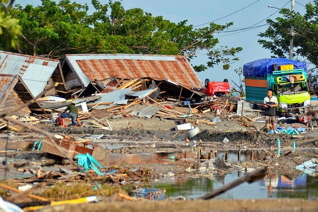 Ein Mann steht inmitten von zerstrten..., Zentral-Sulawesi, verursacht wurden.  | Foto: dpa