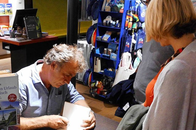 Alex Capus signiert bei der Lesung eines seiner Bcher.  | Foto: Daniel Scholaster