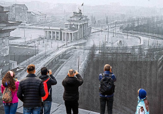 Besucher des Brgerfests in Berlin vor einem historischen Mauerbild  | Foto: dpa
