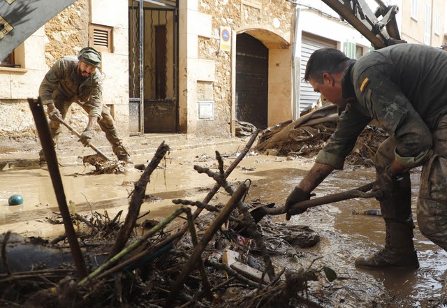 Spanische Soldaten reinigen eine verschlammte Strae.  | Foto: dpa