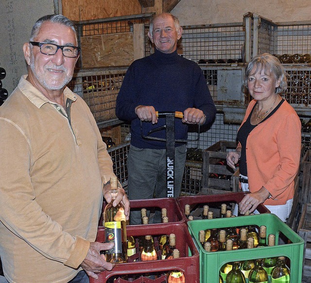 Bob Mull (links) hilft Dieter und Sabine Rsch beim Abfllen ihrer Weine.   | Foto: Lauber
