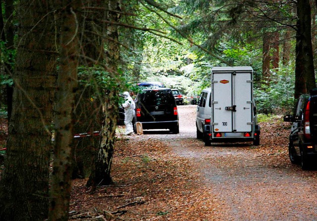 Fahrzeuge stehen in einem Waldstck s... wurde die Leiche des Jgers gefunden.  | Foto: dpa