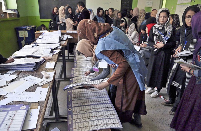 Wahlhelferinnen zhlen die Stimmen aus...r machen Wahlbeobachterinnen Notizen.   | Foto: DPA
