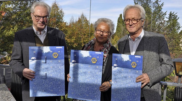 Lions-Prsident Jrgen Hellmuth (links...Barbara Trapp den Adventskalender vor.  | Foto: Ruther