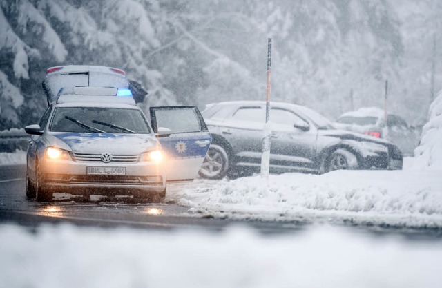 Ein Polizeifahrzeug steht auf dem Feld... rund 15 Zentimeter Neuschnee gegeben.  | Foto: dpa