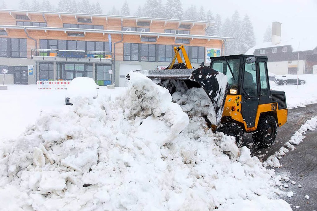 Ein Radlader räumt auf dem Feldberg de...ch gefallenen Schnee von einer Straße.  | Foto: dpa