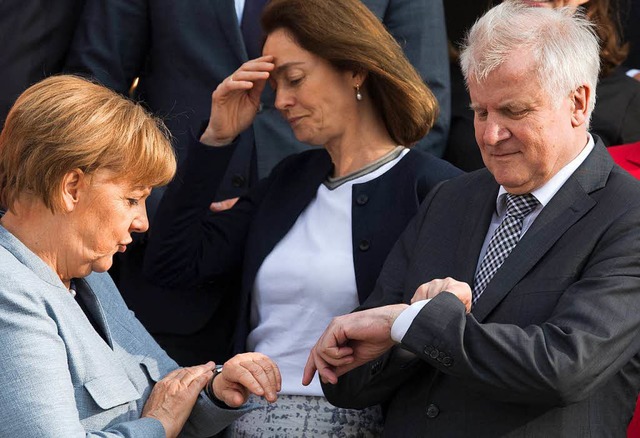Zeit fr Neues: Angela Merkel und Horst Seehofer beim Blick auf die Uhr.  | Foto: dpa