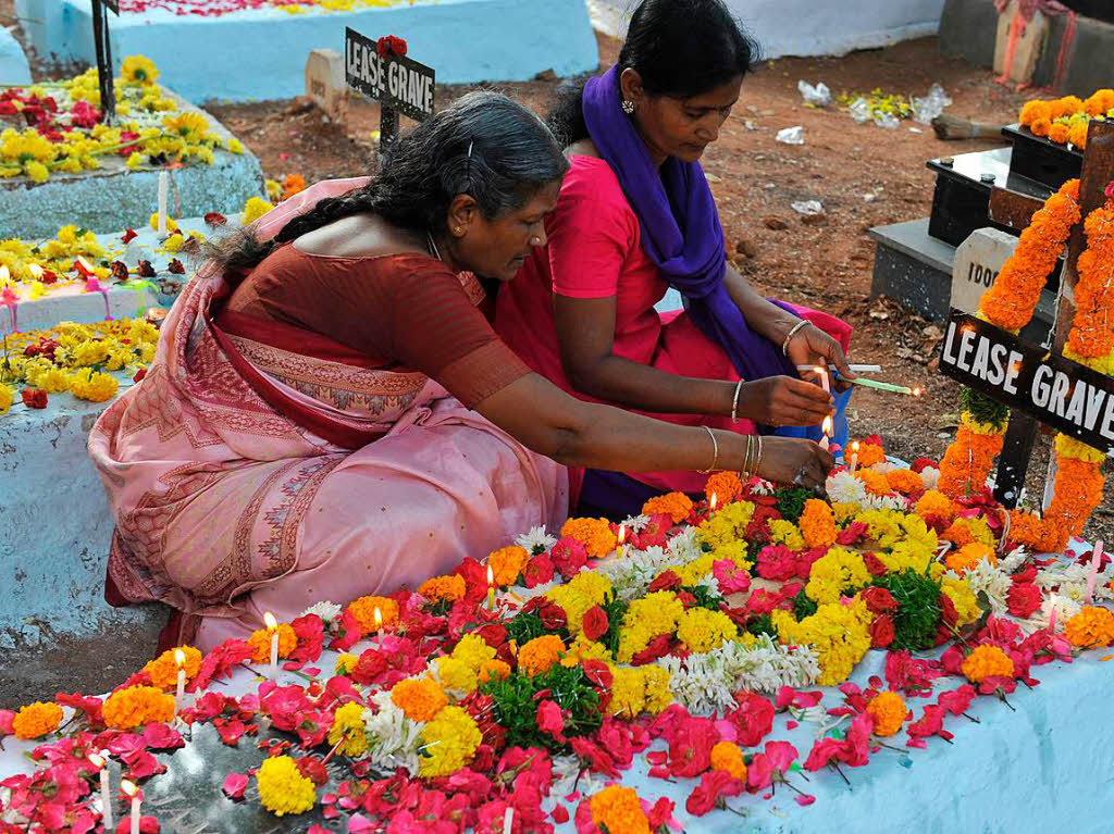 Angehrige schmcken in Indien die Grber der Verstorbenen zu Allerheiligen.