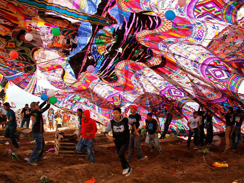 In Santiago Sacatepequez, Guatemala, lassen Menschen bei den Feierlichkeiten traditionell einen 17 Meter hohen Drachen  steigen. Der Drachen wurde von einer Gruppe Maya-Frauen ber einen Zeitraum von drei Monaten hergestellt.