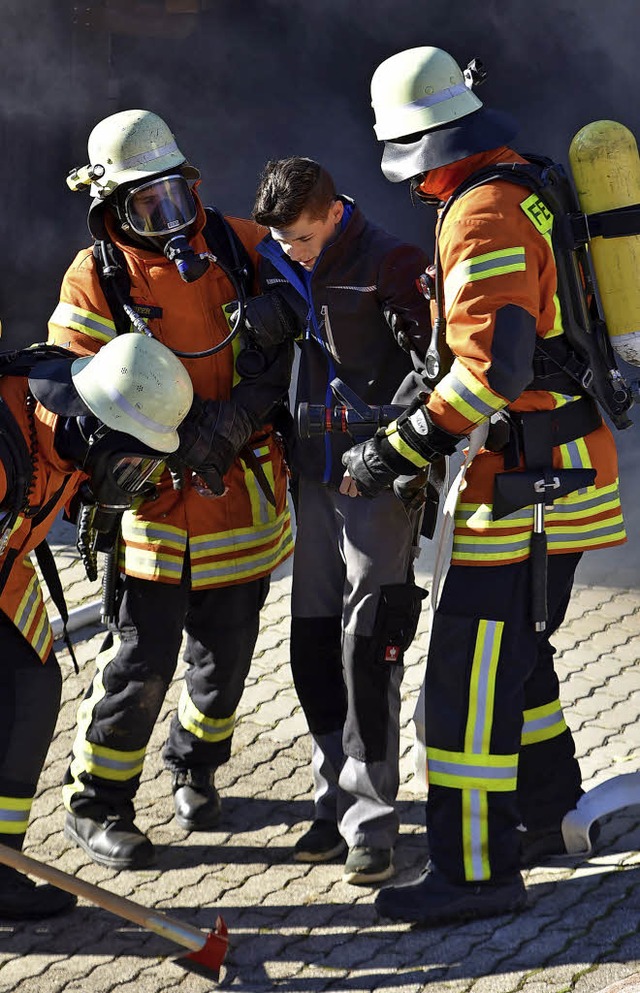 Feuerwehrleute simulieren die Rettung eines Verletzten.  | Foto: Benedikt Sommer