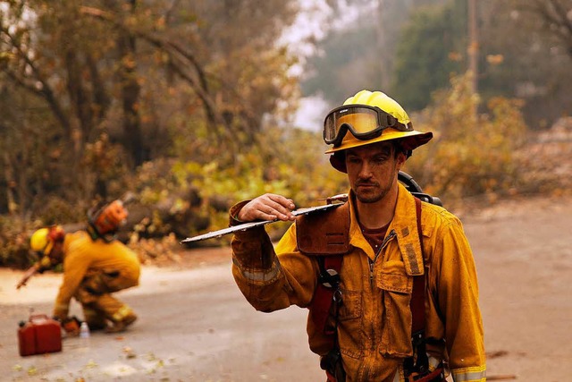 Feuerwehrmann Shawn Slack trgt eine M... die vom Camp Fire verbrannt wurden.  | Foto: dpa