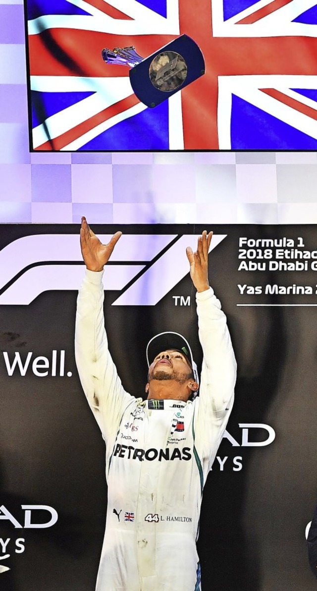 Der Brite Lewis Hamilton wirft den Sie...nd fngt ihn anschlieend wieder auf.   | Foto: AFP