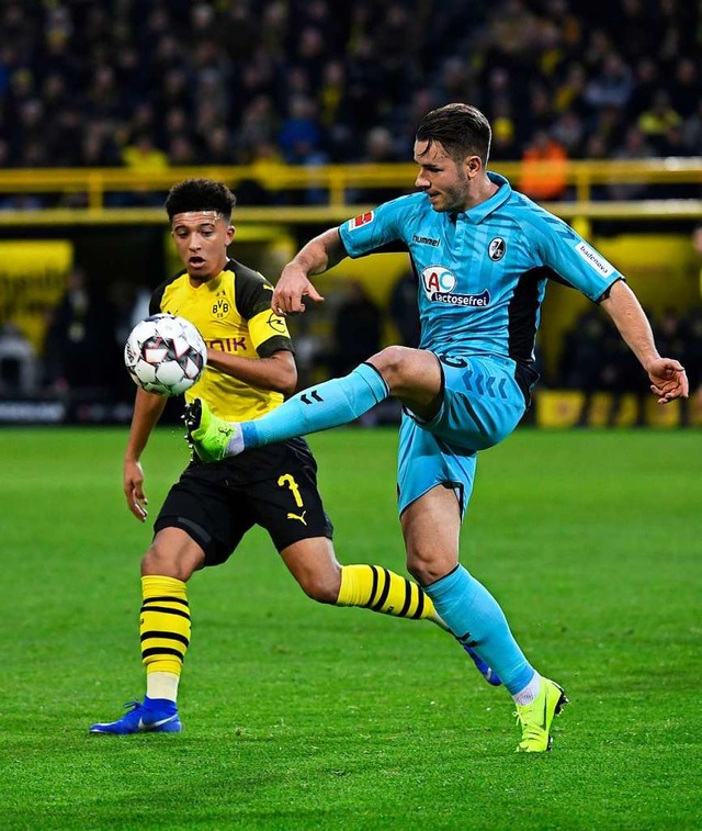 Viel Arbeit mussten die Freiburger Ver...tian Gnter (rechts) vor Jadon Sancho.  | Foto: dpa