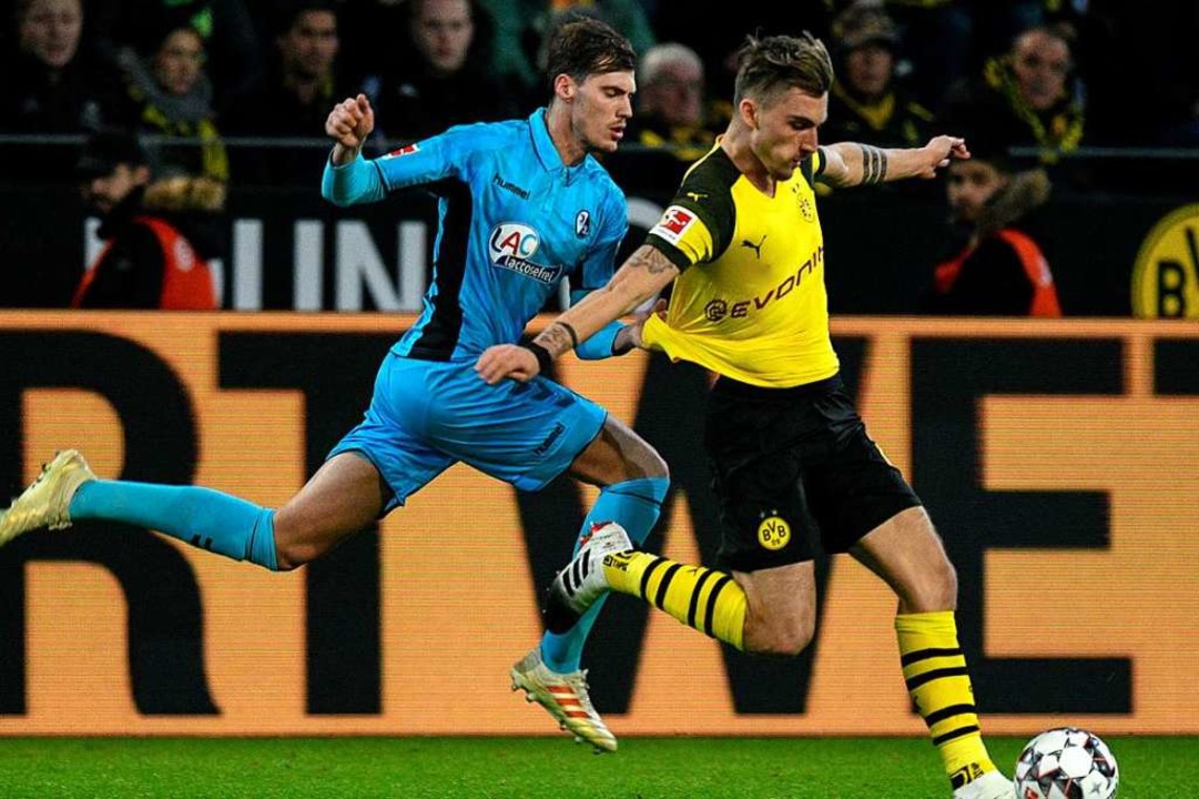 Der ehemalige Freiburger Maximilian Philipp im Duell mit Pascal Stenzel.  | Foto: AFP