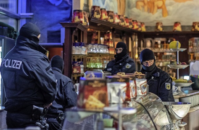 Polizisten stehen in einem Eiscaf  in...onal halten und austauschen zu knnen.  | Foto: dpa