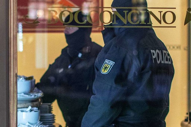 Razzia in Duisburg: Polizisten stehen in einem Eiscaf.  | Foto: dpa