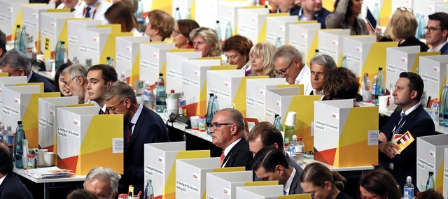 Der Parteitag hat das Wort: Die CDU-De...n in transportablen Wahlkabinchen ab.   | Foto: afp (2)/dpa