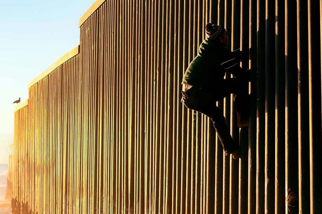 Ein Migrant aus Honduras versucht den ...erikanischen Grenzzaun zu berwinden.   | Foto: AFP