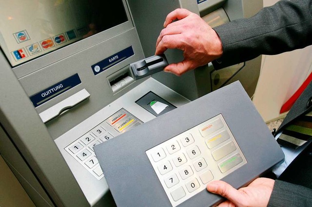 Ein Mitarbeiter der Sparkasse Koblenz ...em Geldautomaten die Skimming-Technik.  | Foto: dpa
