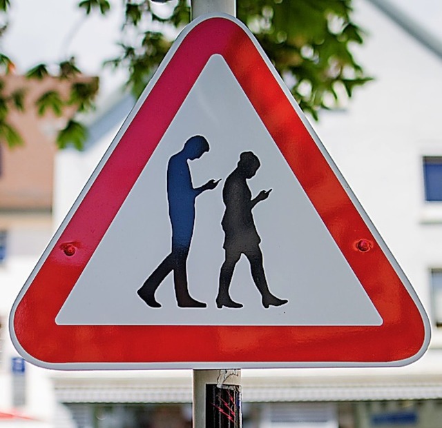 Nur ein Scherz: Ein Schild, das vor Smombies warnt.   | Foto: Christoph Schmidt (dpa)