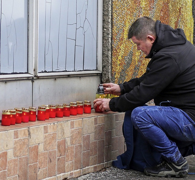 13 Kerzen zndet der Mann fr seine getteten Kumpel an.   | Foto: DPA